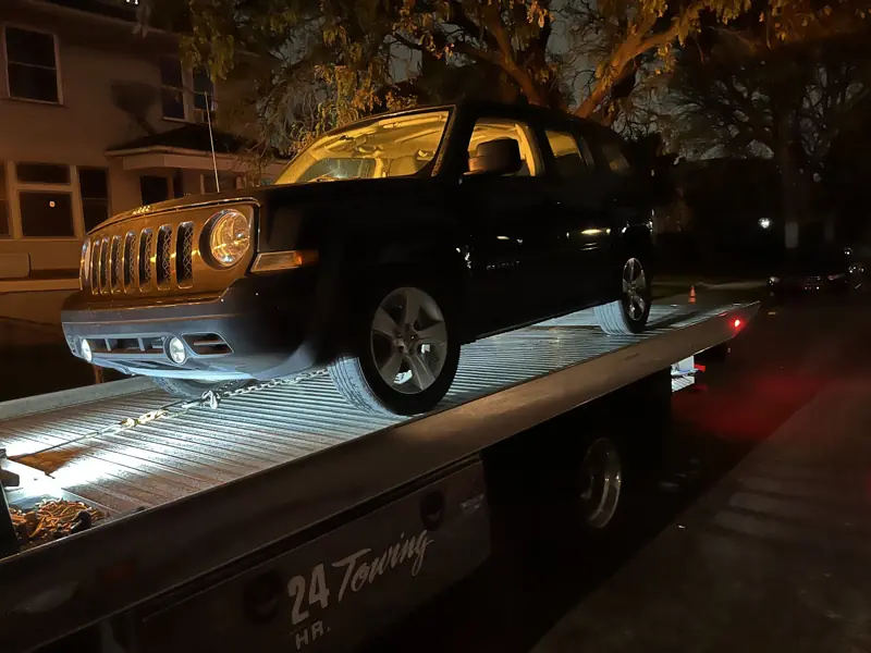 Night tow of a Jeep on the Elite Detroit Towing flatbed